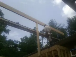 Carpenter setting a ridge beam over a new addition frame — Ice Dam Removal by Roofing Brothers in Bethel Island