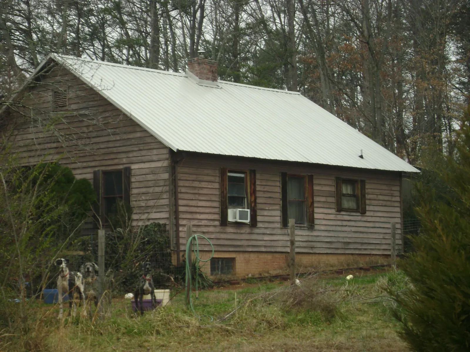 White metal roof on an old wood sided farmhouse, from a Metal Roof Installation job in Bethel Island